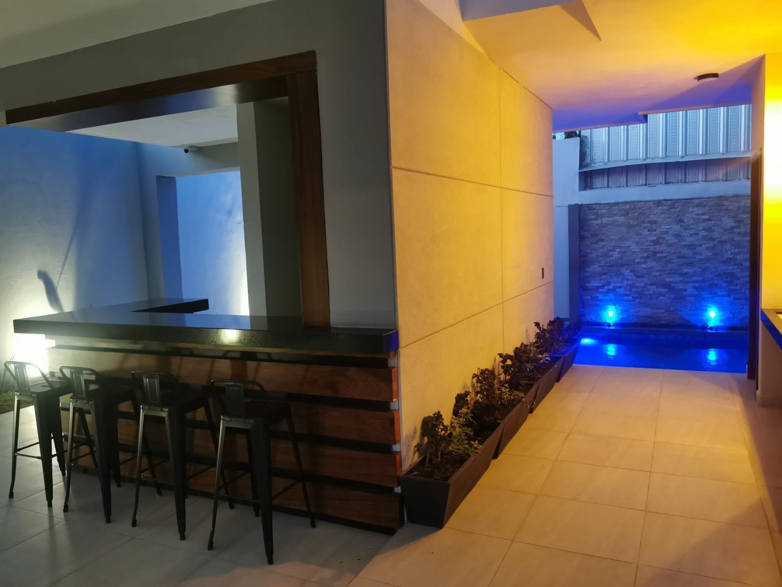 Pasillo Exterior con Iluminación Nocturna - Terraza La Opulenza